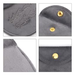A grey velvet jewelry pouch featuring a snap button closure and a soft interior. Includes a logo.