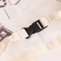A reusable linen bread bag in a beige hue, featuring a black buckle on a strap. It has a logo printed on the surface.