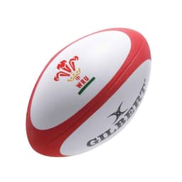 A white stress rugby ball with red accents and a logo. It features a smooth surface typical of stress balls.