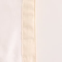 A close-up of a cream-coloured reusable linen bread bag with a textured edge and faint seam detailing.