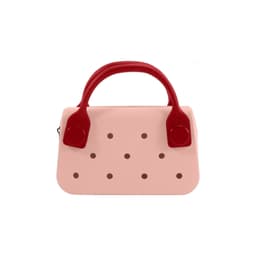 A pink mini handbag with red handles featuring circular holes along the front. It has a simple, stylish design.