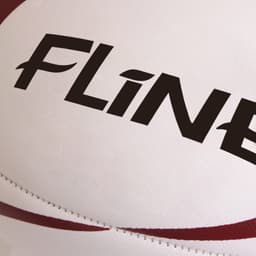 A rugby ball with a white surface and red accents, featuring a branding logo.