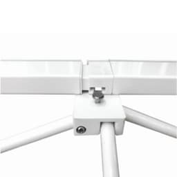 A close-up of a white metal connection joint for a pop-up display wall. It features a silver screw and vertical supports.