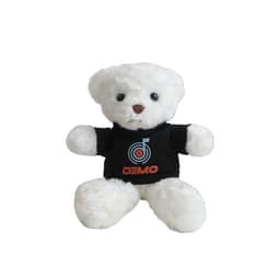A white bear plush toy wearing a black T-shirt with a logo. The toy has round eyes and a cute expression.