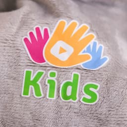 A plush surface featuring colourful hand graphics and the word "Kids" in bright green lettering.