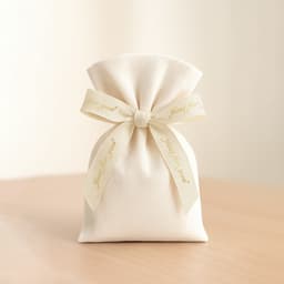 A cream cotton pouch tied with a hot stamping ribbon, featuring a bow and a logo.