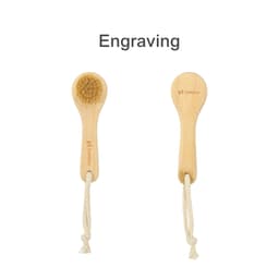 A natural wooden face brush with a bristle head and a wooden handle, featuring a rope tie.