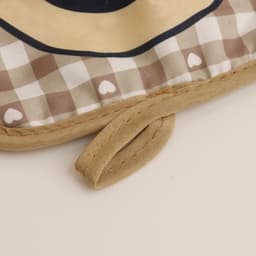 A medium quilted pot holder featuring a checkered pattern in beige and brown, with a fabric loop for hanging.
