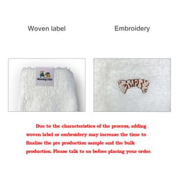A pair of white coral fleece socks with a woven label and embroidered detailing. Footwear product for promotional use.