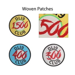 Four custom woven patches in various colours, featuring circular designs with different numerical values and a logo.