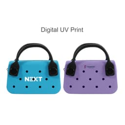 A mini handbag in blue and purple with perforated designs and a black handle. Features a logo on the blue bag.