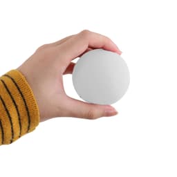 A hand holding a plain white bouncy ball, showcasing its smooth surface and round shape.