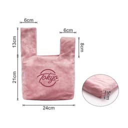 A pink velvet knot wrist bag with a logo, featuring a rectangular body and dual handles. Dimensions included.