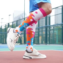 Knee high socks featuring a vibrant pattern of pink, blue, and white, paired with sporty footwear.