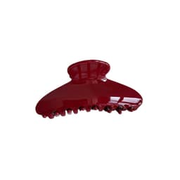 A deep red acetate hair clip with a curved design and multiple gripping teeth. It features a shiny finish and branding.