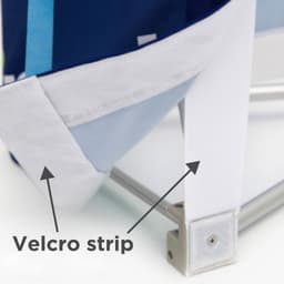 A close-up of a Velcro strip attached to the corner of a fabric display panel in blue and white.