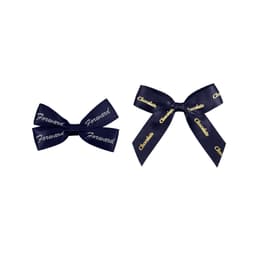 Two adhesive bows in dark blue, featuring text patterns in gold. One bow is larger and the other smaller.
