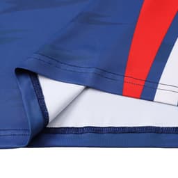 A close-up of a blue long-sleeved T-shirt featuring red and white stripes and a logo.