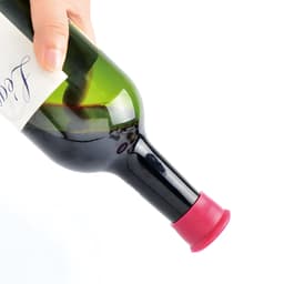 A drink bottle with a red silicone wine stopper securely fitted at the opening, held by a hand.