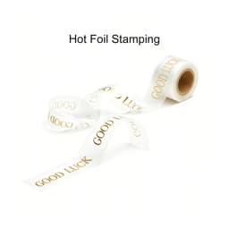 A roll of transparent ribbon with a gold hot foil stamped message reading "GOOD LUCK."