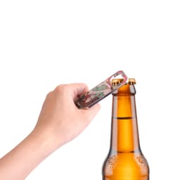 A drink bottle opener in a hand, designed as a fridge magnet, features a colourful pattern. It has a logo.