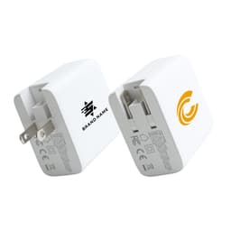 A white universal travel adapter with four ports and a logo on one side, featuring a compact design.