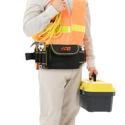 A waist tool bag in black with red accents, worn by a person holding a yellow tool box and wearing a high-visibility vest.