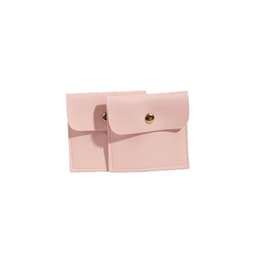 A pair of square, pink PU leather jewelry pouches with a snap closure and decorative gold button.