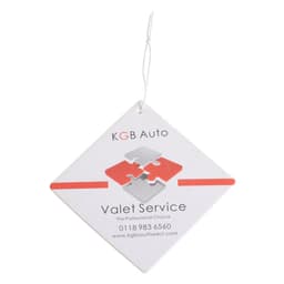 A square air freshener in white with red and grey puzzle design, featuring a hanging string and a logo.