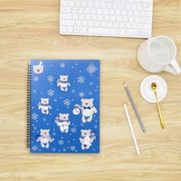 A blue loose-leaf folder featuring bears in winter attire, surrounded by snowflakes. It has a spiral binding and a logo.
