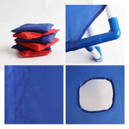 A blue portable cornhole game board with red and blue bean bags stacked beside it. It has a circular hole and piping details.