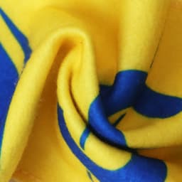 A vibrant yellow and blue fleece scarf with a soft, textured appearance and a subtle pattern. It features a logo.