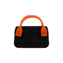 A mini handbag in black with orange handles and decorative holes on the front. It features a logo.