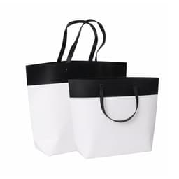 Large black and white boutique paper bags with long handles, featuring a sleek design. Includes a logo.