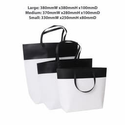 Three paper bags in black and white, featuring a large, medium, and small size with handles, and a logo on the large bag.