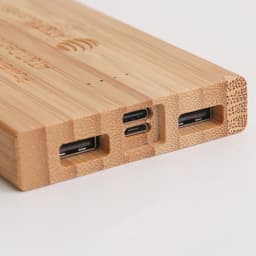 A bamboo power bank with multiple charging ports, featuring a natural wood finish. It includes USB and USB-C connections.