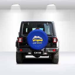 A blue spare tyre cover with a design featuring a car and the text "CAR WASH," placed on a black vehicle.