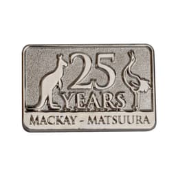 A metallic lapel pin featuring a kangaroo and an emu, with the text "25 YEARS MACKAY - MATSUURA."