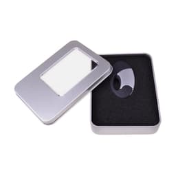 A large silver tin case with a transparent window, containing a black item on cushioned black foam.