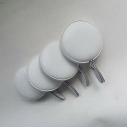 A set of four white PU mini tape measures with metal keychain clips.