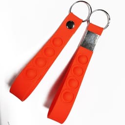 An orange silicone keychain wristband featuring round pop-it bubbles and metal attachment rings.