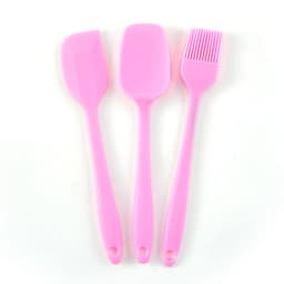 A silicone baking set in vibrant pink, featuring a spatula, a mixing spoon, and a basting brush.