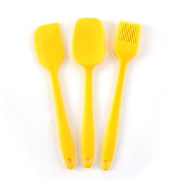 A silicone baking set featuring three yellow utensils: a spatula, a scraper, and a basting brush.