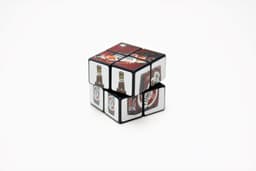 A 2x2 Rubik's Cube in black featuring images of drinks on its sides.