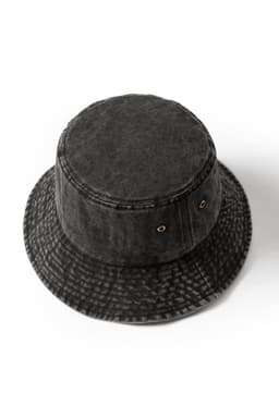 A black washed bucket hat made from 280gsm 100% cotton drill, featuring eyelets and a textured design.