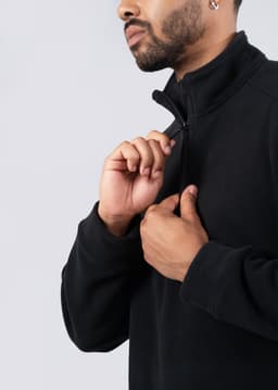 A black polar fleece half zip top for men/unisex, featuring a high collar and zipper detail.