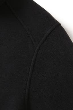 A close-up of a black polar fleece half zip top, showcasing the texture and stitching details.