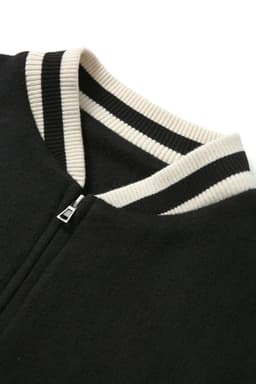 A black wool blend varsity jacket featuring a zip and cream-coloured ribbed collar with black stripes.