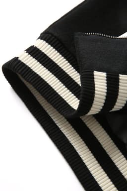 A close-up of a black and ivory striped collar of a wool blend varsity jacket. The fabric has a soft texture.