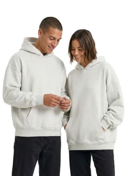 A grey oversized hoodie displayed on two individuals with a casual style. The hoodies feature pockets and a logo.
